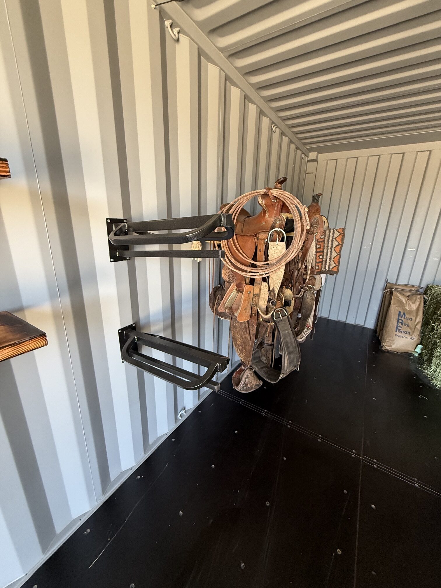 Interior of a 20-foot container tack shed by Conex Creation & Supply showing heavy-duty saddle and blanket racks for organized horse tack storage on Southern Arizona ranches.