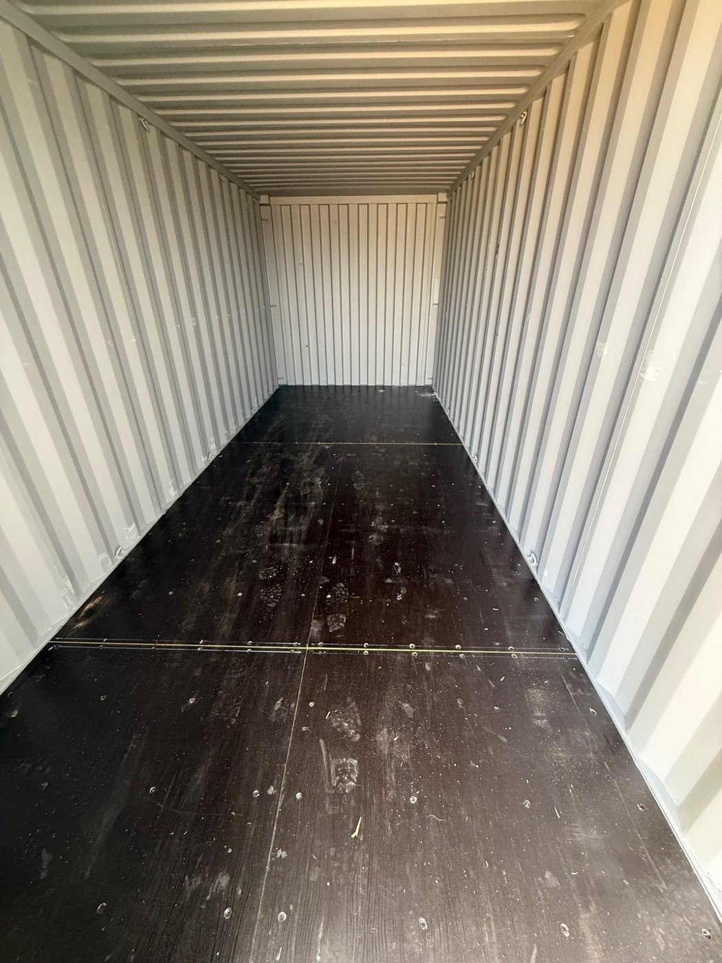 Clean interior of a new 20-foot one-trip shipping container showing corrugated steel walls and wood floor, suitable for mobile office container builds and custom container projects in Tucson and Southern Arizona.
