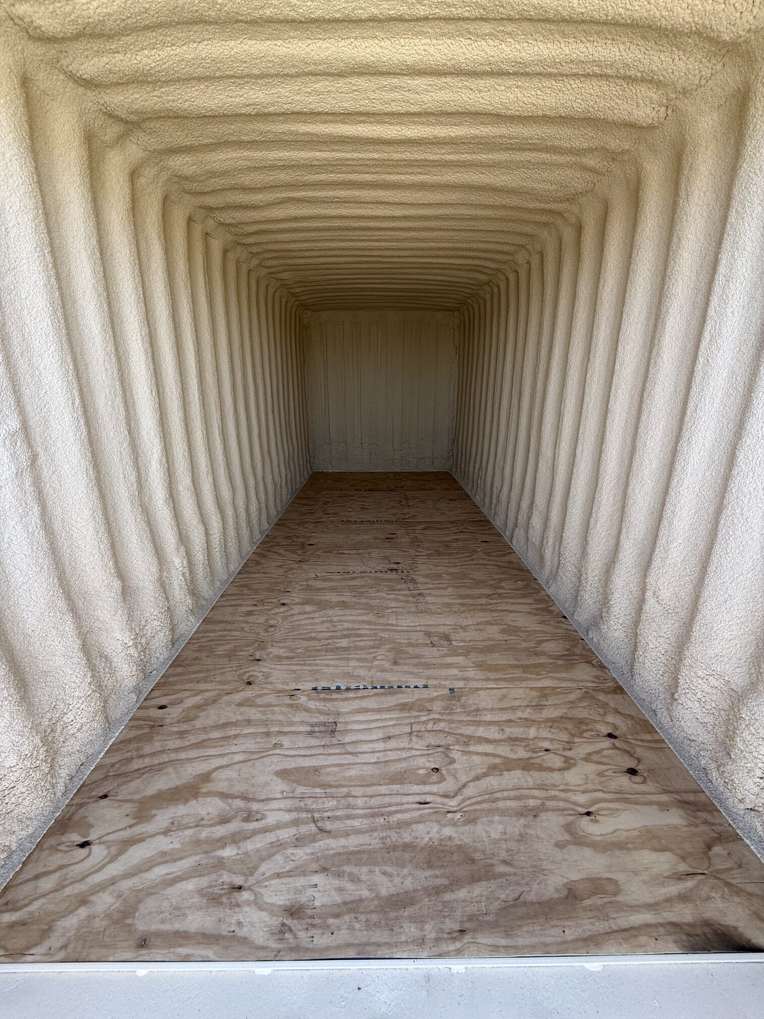 Interior of a 20-foot insulated shipping container with spray foam insulation and new plywood floor available for rent or sale in Tucson and Southern Arizona from Conex Creation & Supply